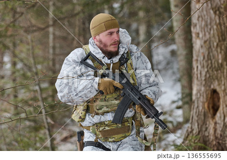 Armed Soldier In Winter Camouflage Patrol Carrying Rifle Through Snowy Forest During Training Operation Armed Soldier In Winter Camouflage Patrol Carrying Rifle Through Snowy Forest During Training Operation 136555695