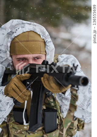 Soldier Aiming Assault Rifle in Winter Snow Wearing White Camouflage, Tactical Gear and Gloves Soldier Aiming Assault Rifle in Winter Snow Wearing White Camouflage, Tactical Gear and Gloves 136555699