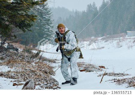 Soldier On Winter Patrol in Snowy Forest Wearing White Camouflage and Tactical Gear With Rifle Soldier On Winter Patrol in Snowy Forest Wearing White Camouflage and Tactical Gear With Rifle 136555713