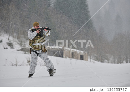 Soldier in Winter Camouflage Aiming Rifle During Snowy Military Training Patrol in Forest Soldier in Winter Camouflage Aiming Rifle During Snowy Military Training Patrol in Forest 136555757