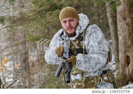 Winter Soldier in White Camouflage Holding Rifle Patroling Snowy Forest During Cold Weather Operation Winter Soldier in White Camouflage Holding Rifle Patroling Snowy Forest During Cold Weather Operation 136555759