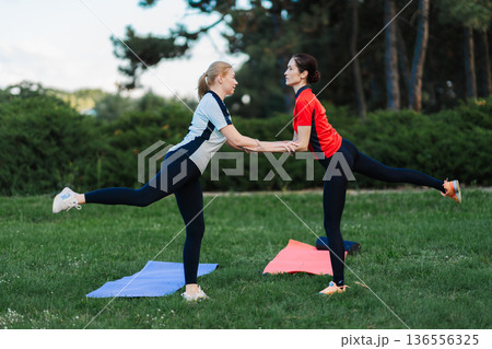 Two people exercise together in the park 136556325