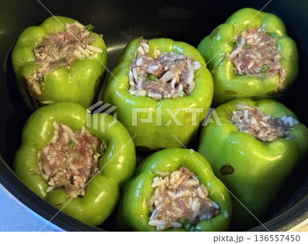 Stuffed green peppers in a pot ready for cooking, showcasing a home-cooked meal Stuffed green peppers in a pot ready for cooking, showcasing a home-cooked meal 136557450