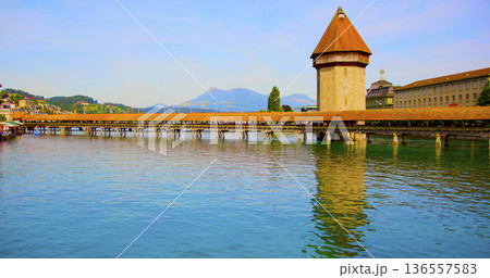 View of historic building by lake with mountains in the background during daytime View of historic building by lake with mountains in the background during daytime 136557583