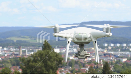 Drone flies over a city with mountains in the background on a clear day Drone flies over a city with mountains in the background on a clear day 136557644