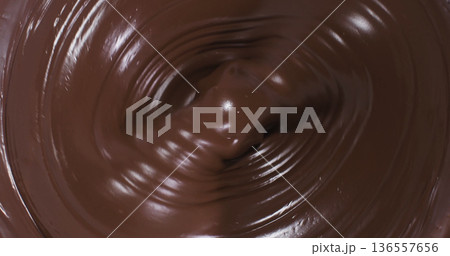 Mixing chocolate in a bowl at a kitchen counter during a baking session in the afternoon Mixing chocolate in a bowl at a kitchen counter during a baking session in the afternoon 136557656