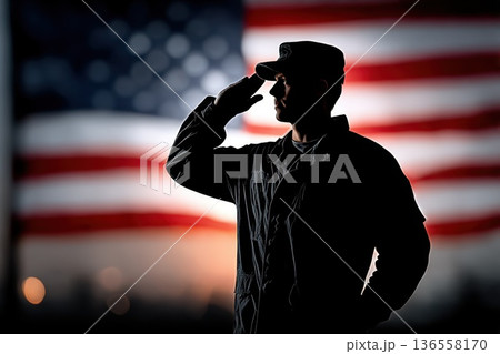 Soldier silhouette in salute posture against a softly blurred American flag background featuring vibrant red and blue colors, emphasizing patriotism and military respect 136558170
