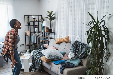 Young woman screaming because her apartment is a mess Young woman screaming because her apartment is a mess 136559092