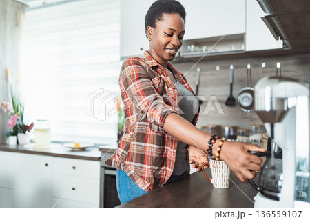Young woman preparing coffee in her modern kitchen Young woman preparing coffee in her modern kitchen 136559107