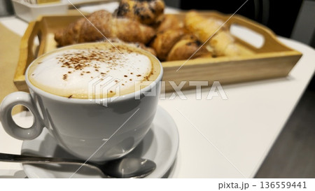 Delicious Cappuccino with Fresh Pastries on a White Table 136559441