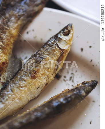 Montenegrin cuisine, fish assortment platter, fried grilled crucian carp steak, roasted pastrmka and bleak on plate with lemon and salad served in a restaurant in Montenegro, Skadar lake, Virpazar 136560216