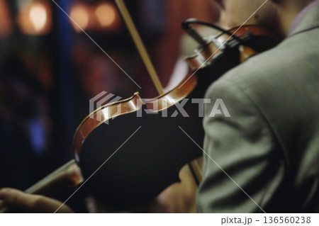 Concert view of violinist with vocalist and musical band, fiddler performing classical music, symphony orchestra performing music, violin player on stage in a club, music arena hall, fiddle and bow 136560238