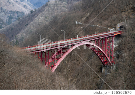 冬の奥秩父の彩甲斐街道に架かる赤いアーチ橋「豆焼橋」と山々の風景 136562670