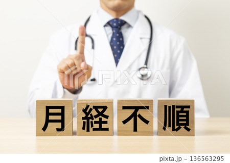 「月経不順」と書かれたブロックと医師 136563295