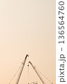 A tall construction crane and an orange sky background. 136564760