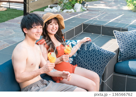 プールサイドのジャグジーでくつろぐ水着姿のアジア人カップル 136566762