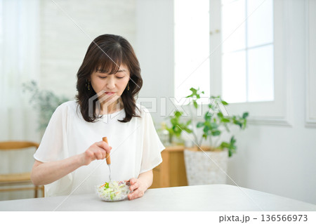 リビングでサラダを食べる60代女性 リビングでサラダを食べる60代女性 136566973
