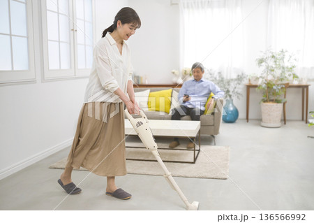 会話をしながら掃除機をかける笑顔の女性と60代の男性 会話をしながら掃除機をかける笑顔の女性と60代の男性 136566992