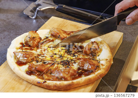 包丁で切り分ける照り焼きチキンピザ 包丁で切り分ける照り焼きチキンピザ 136567279
