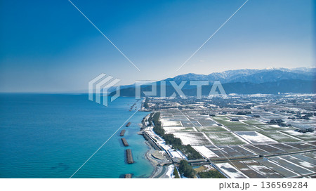 少し雪解けをした日本の富山県にある黒部川扇状地と海岸線 少し雪解けをした日本の富山県にある黒部川扇状地と海岸線 136569284