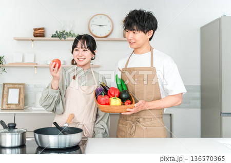 キッチンで野菜を持つ若いアジア人男女,カップル,夫婦 136570365