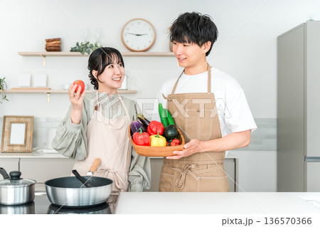 キッチンで野菜を持つ若いアジア人男女,カップル,夫婦 136570366