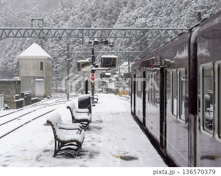 雪が積もる駅に停車する能勢電鉄の5100系電車 136570379