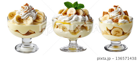 Banana pudding dessert with whipped cream and mint leaves in glass cup, isolated on white background, concept of sweet treat Banana pudding dessert with whipped cream and mint leaves in glass cup, isolated on white background, concept of sweet treat 136571438