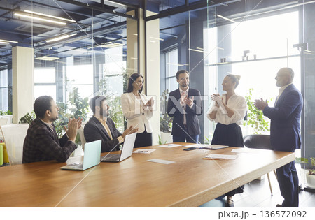 Business people clap hands to celebrate success of presentation or negotiations Business people clap hands to celebrate success of presentation or negotiations 136572092