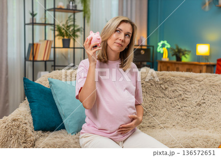 Pregnant woman shaking empty piggy bank sad planning budget dreaming improvement from poverty future 136572651