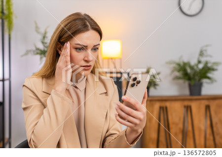 Businesswoman reads credit refusal on smartphone bad news game loss sighs disappointed reaction look 136572805