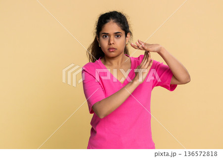 Indian woman forming timeout gesture with hands, looking seriously at camera requesting short break Indian woman forming timeout gesture with hands, looking seriously at camera requesting short break 136572818