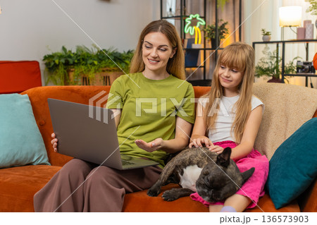 Mother daughter dog start online study on laptop sit down together focus learn skill lesson teamwork 136573903