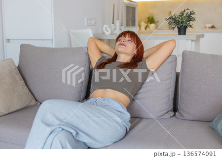 Young woman sits down and relaxes after work slow breath calm mood gentle pause and rest with peace Young woman sits down and relaxes after work slow breath calm mood gentle pause and rest with peace 136574091
