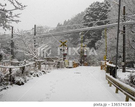 雪が積もる能勢電鉄妙見線の踏切 136574316