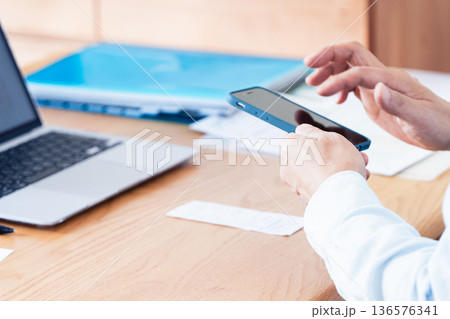 パソコンとスマホで確定申告の準備をする男性 パソコンとスマホで確定申告の準備をする男性 136576341