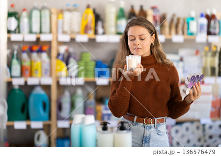 Young woman choosing scented candles in store Young woman choosing scented candles in store 136576479