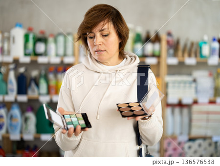 Adult woman choosing eyeshadow and sculptor in store 136576538