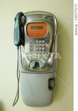 Vintage public telephone communication on yellow wall in Thailand 136577271