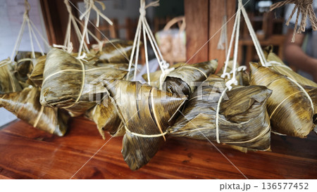 Zongzi, an ancient Chinese traditional dish wrapped in fragrant leaves, crafted with fine ingredients and cherished in cultural festival rituals. 136577452