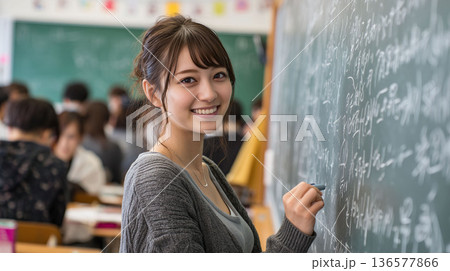 生徒がノートを取る前で黒板授業を行う大学生アルバイト講師、冬期講習の塾求人向けビジュアル 136577866