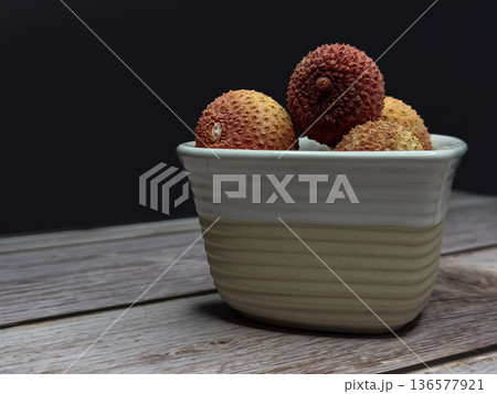 Lychee Fruit in Ceramic Bowl on Wooden Table with Copy Space 136577921