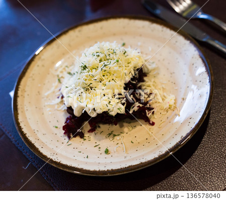 mix of beets, cheese, mayonnaise on a plate in restaurant 136578040