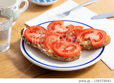 two bruschettas with tomato slices on a plate two bruschettas with tomato slices on a plate 136578042