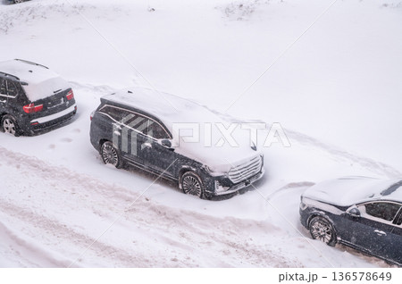 Cars buried in heavy snow on urban street during winter blizzard Cars buried in heavy snow on urban street during winter blizzard 136578649