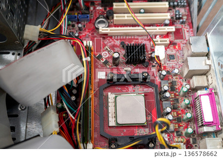 Close-up of red computer motherboard with cpu and wires visible Close-up of red computer motherboard with cpu and wires visible 136578662