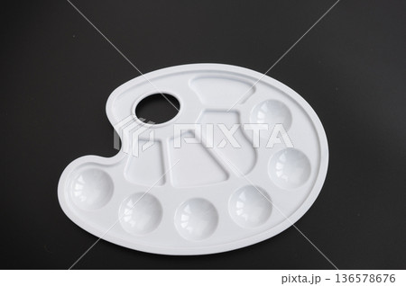 White oval artist palette with mixing wells on black background 136578676