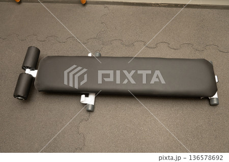 Flat workout bench on carpeted gym floor in fitness center Flat workout bench on carpeted gym floor in fitness center 136578692