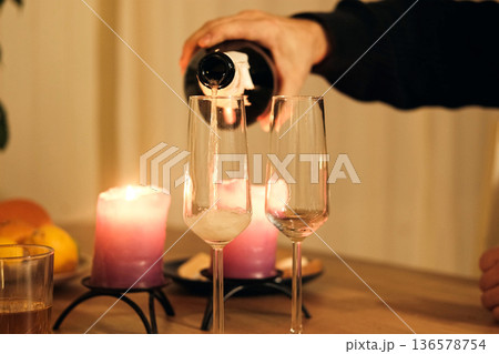 Champagne being poured into champagne flute, bubbles. Sparkling beverage. Romantic Dinner Table with Flickering Candles, Flutes. Warm ambiance. Glasses of champagne. Celebration, Anniversary, Luxury Champagne being poured into champagne flute, bubbles. Sparkling beverage. Romantic Dinner Table with Flickering Candles, Flutes. Warm ambiance. Glasses of champagne. Celebration, Anniversary, Luxury 136578754