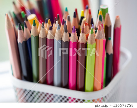 Close-Up of Vibrant Collection of Colorful Colored Pencils in a pen holder. Creative Art. Colourful assortment of sharpened colored pencils for art projects, drawing, and creativity. Artist's studio 136578759